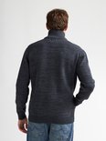 Man van achteren gezien, draagt donkerblauw gemêleerd gebreid vest met ritssluiting en hoge kraag.