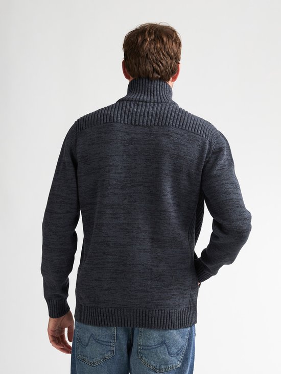 Man van achteren gezien, draagt donkerblauw gemêleerd gebreid vest met ritssluiting en hoge kraag.