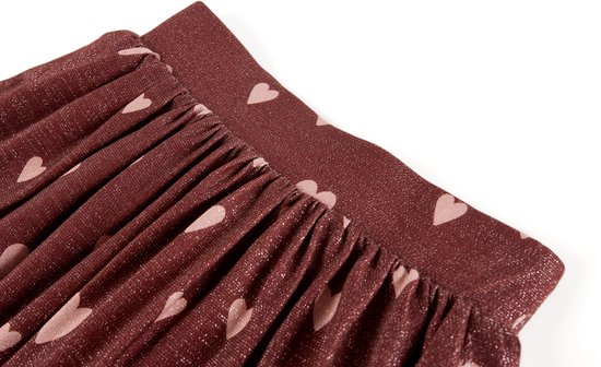 Sluiting en ceintuur van bordeauxrode rok met roze hartjesprint.