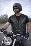 Man met baard draagt een zwart leren bikerjack, helm en zonnebril, leunend op een motorfiets.
