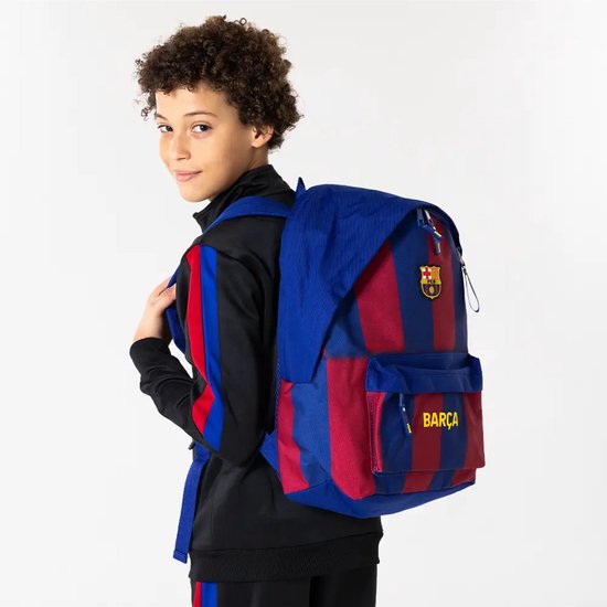 Jongen draagt blauwe rugzak met rode strepen, FC Barcelona logo en 'Barça' tekst.