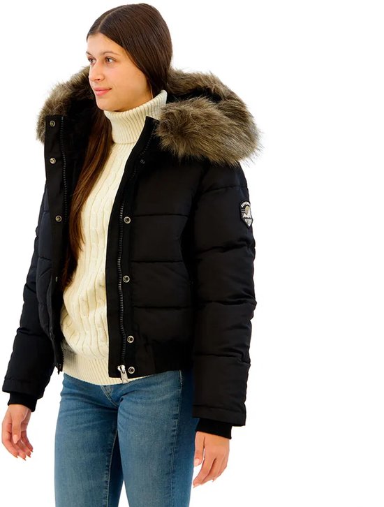 Model met een zwarte Superdry bomberjack met dikke bontkraag, witte coltrui en spijkerbroek.