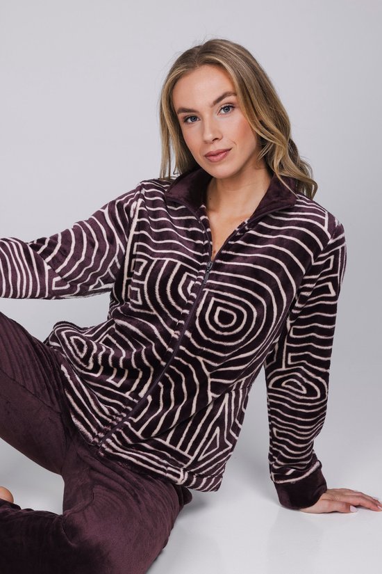 Model in een paars huispak met cirkelvormig patroon en ritssluiting, en een paarse broek.