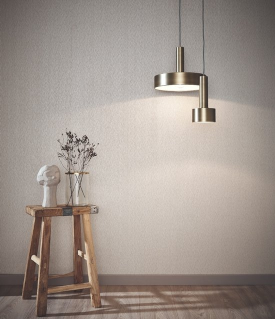 Een woonkamer met zilverwit vliesbehang met een verticale zandkorrel structuur, verlicht door moderne lampen.