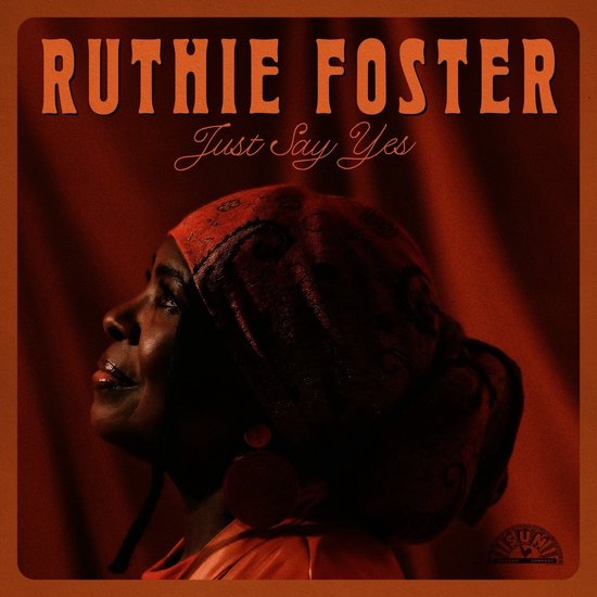 Ruthie Foster - Just Say Yes album cover, portret van een vrouw in oranje hoofddoek en oranje jurk.