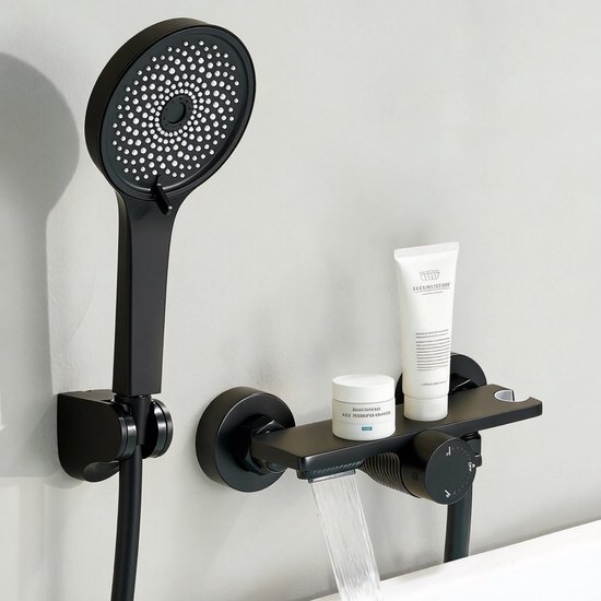 Robinet de baignoire mural noir mat avec douchette et sortie cascade, avec des articles de toilette.