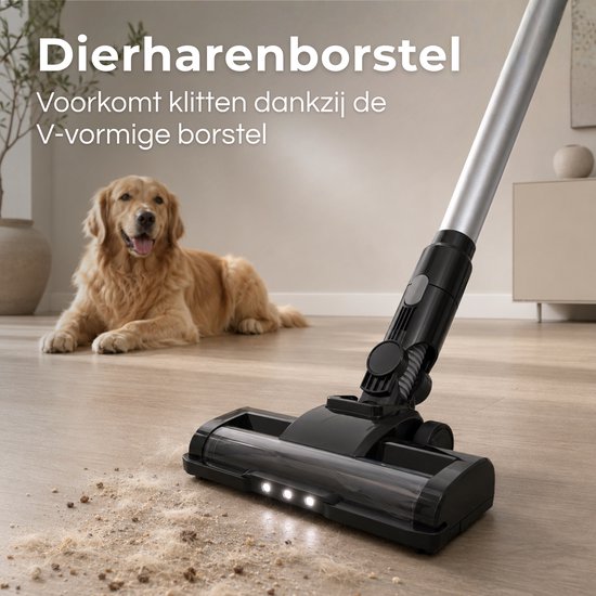 Close-up van een zwarte steelstofzuigerkop met V-vormige borstel die dierenharen opzuigt van een houten vloer. Een Golden Retriever ligt op de achtergrond. "Dierenharenborstel Voorkomt klitten dankzij de V-vormige borstel".