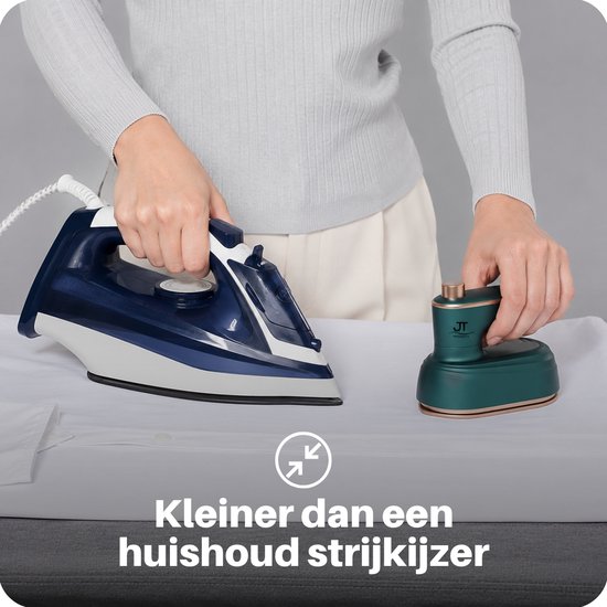 Groen mini reisstrijkijzer naast een groter blauw-wit strijkijzer, beide op wit linnen.