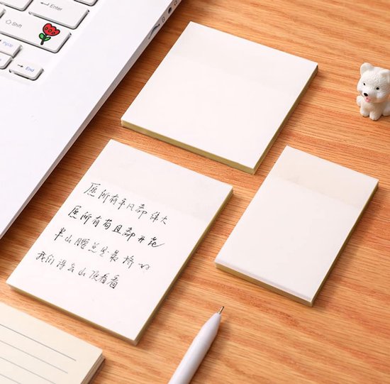 Transparante memoblaadjes op een houten bureau, één met handgeschreven tekst.