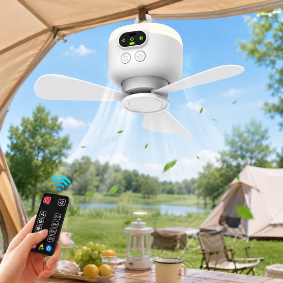 Ventilateur de camping blanc suspendu à un crochet sous une toile de tente, avec une télécommande dans une main, à l'extérieur près d'un lac.