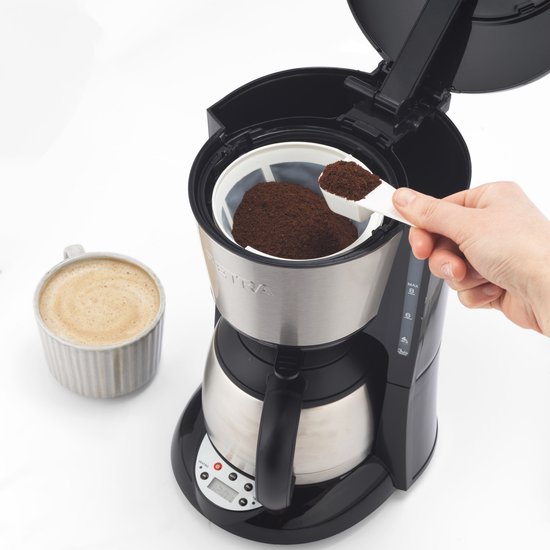 Schepje gemalen koffie in filter van zilverkleurig Petra koffiezetapparaat.
