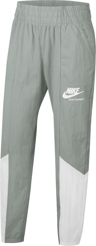Lichtgrijze Nike trainingsbroek met witte vlakken op de pijpen en een Nike Sportswear logo.