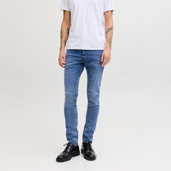 Man met slanke blauwe jeans en witte t-shirt, voorkant.