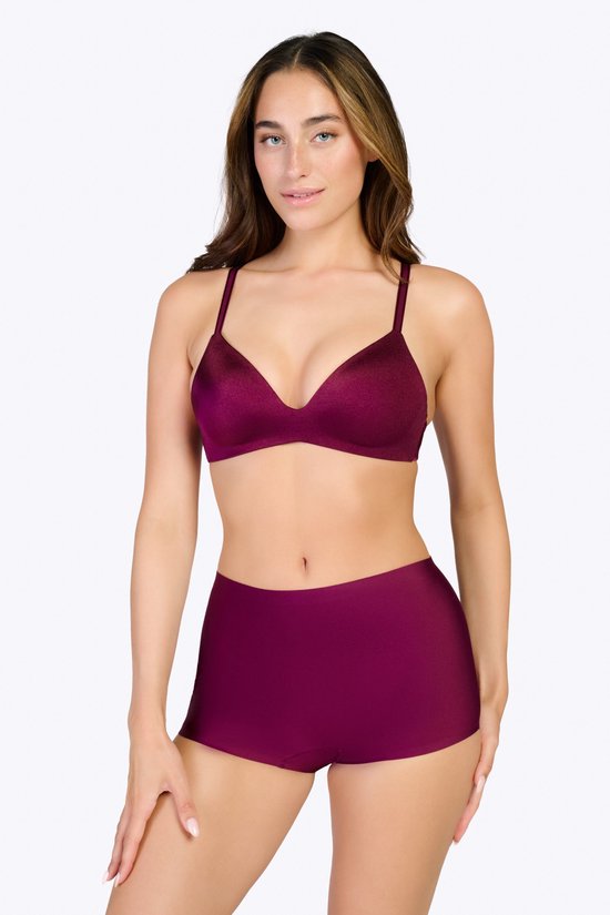 Vrouw met lang bruin haar, draagt bordeauxrode beha en slip, van voren gezien.