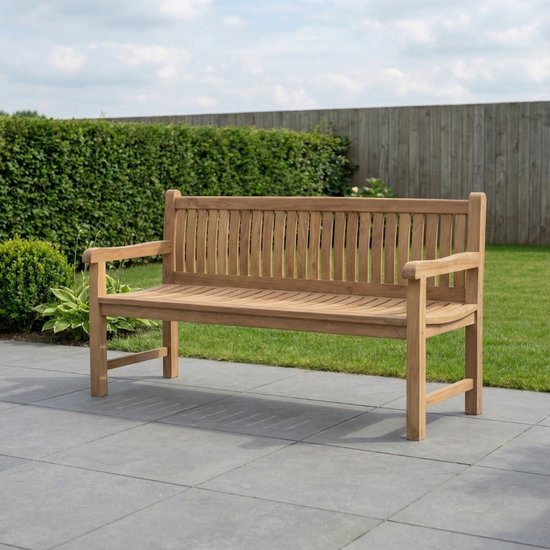 Houten tuinbank op terras met groen van gazon en heg op achtergrond.