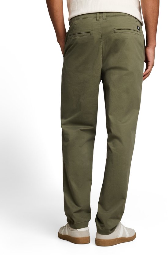 Achterkant van een man die een olijfgroene chino met een relaxte pasvorm draagt.