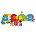 Blauwe locomotief met gele details trekt wagons met nummers 1 t/m 9. Twee kinderen, een hondje en een blok met cijfer 0.