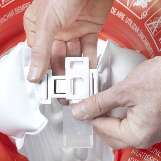 Handen klikken de witte gespen van de rode zwemband met witte opblaasbare armsteunen vast.