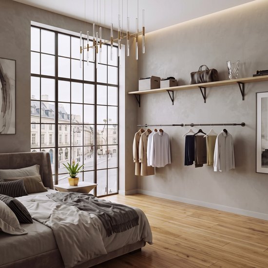Een kledingstang met diverse kledingstukken in een moderne slaapkamer met groot raam.