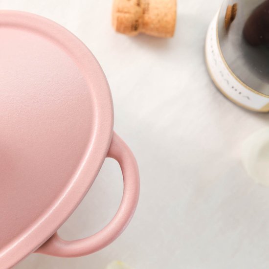 Roze gietijzeren braadpan in hartvorm met handvatten, detail van het deksel.