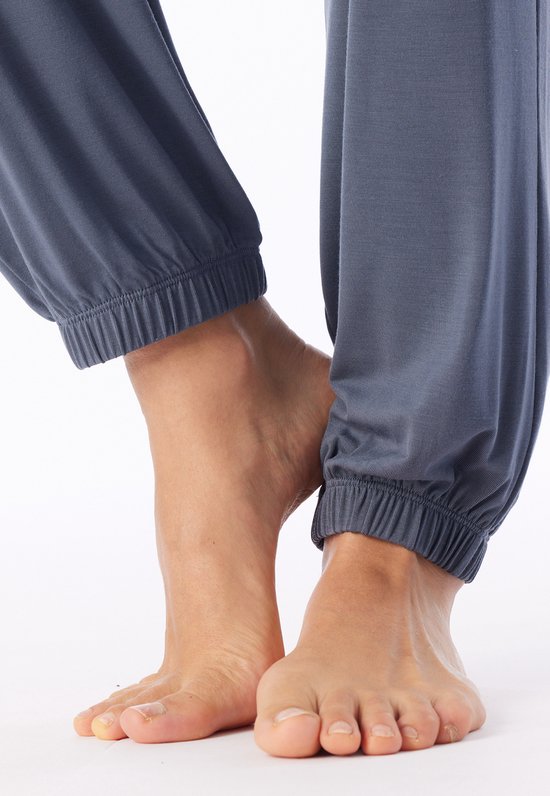 Close-up van de enkels in de blauwe pyjamabroek met elastische zoom.