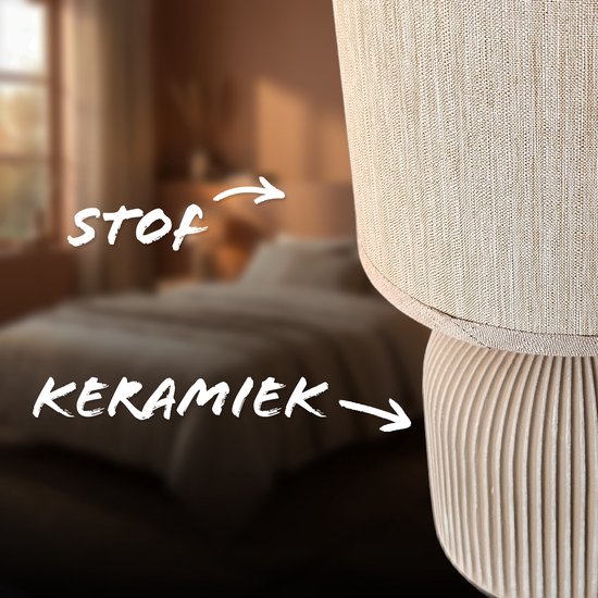 Gros plan d'une lampe de table avec un abat-jour en tissu beige et un pied en céramique nervuré.