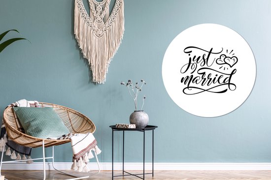 Un cercle mural avec le texte 'just married' en écriture élégante, avec deux cœurs au-dessus.