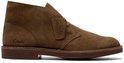 Bruine suède woestijnlaarsjes van Clarks met een kenmerkende zool en het Clarks-logo op de zijkant.