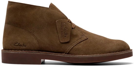 Bruine suède woestijnlaarsjes van Clarks met een kenmerkende zool en het Clarks-logo op de zijkant.