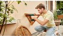 Man monteert een houten rek aan een muur met een Bosch EasyDrill 18V-40 boormachine.