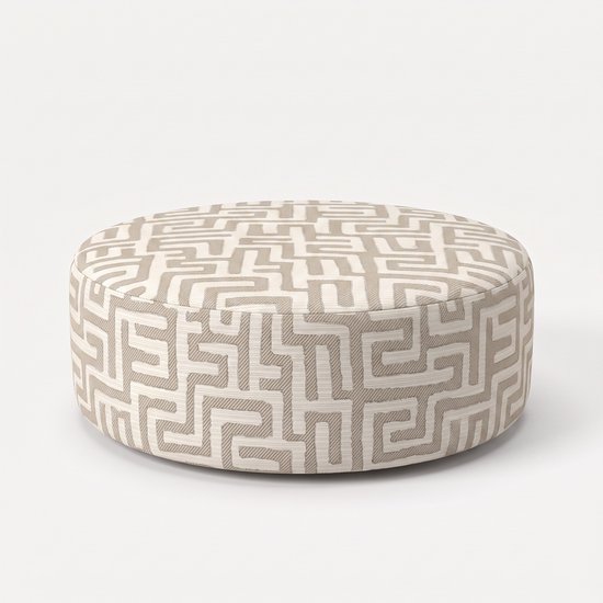 Ronde poef met een beige en wit labyrintpatroon.