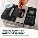 Hand voegt rozijnen toe aan de broodbakmachine.