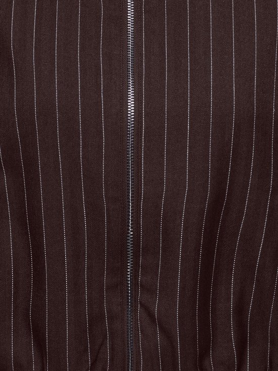 Detail van bruin pinstripe bomberjack met zilverkleurige ritssluiting.