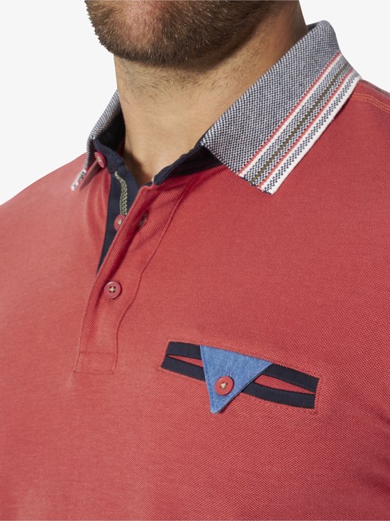 Detailopname van de kraag en borstzak van een lichtrood poloshirt met een gestreepte kraag en contrasterende knopen.