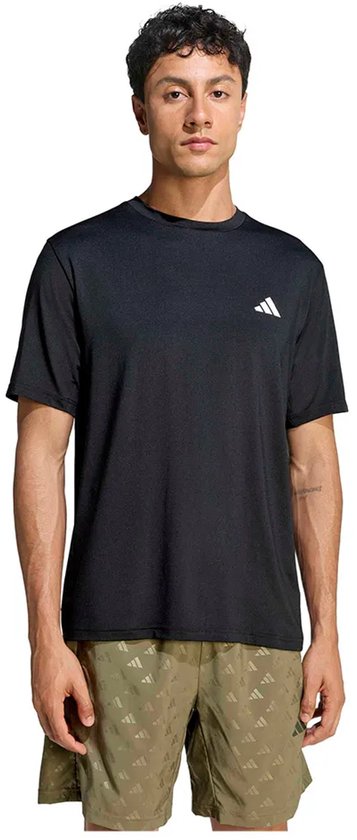 Man met zwarte Adidas T-shirt en olijfgroene shorts met Adidas logo-print.