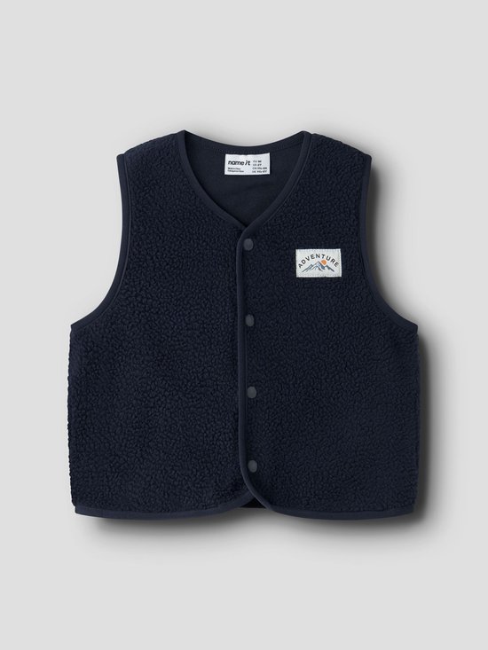 Donkerblauw teddy gilet met drukknopen en een ADVENTURE-embleem op de borst.