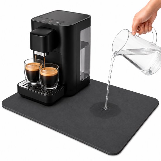 Een zwarte koffiezetapparaat met twee glazen espresso op een donkergrijze, absorberende mat. Water wordt in het apparaat gegoten.