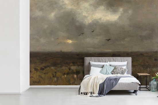 Une chambre avec un lit et des oreillers, face à un tableau de marais avec un ciel nuageux.