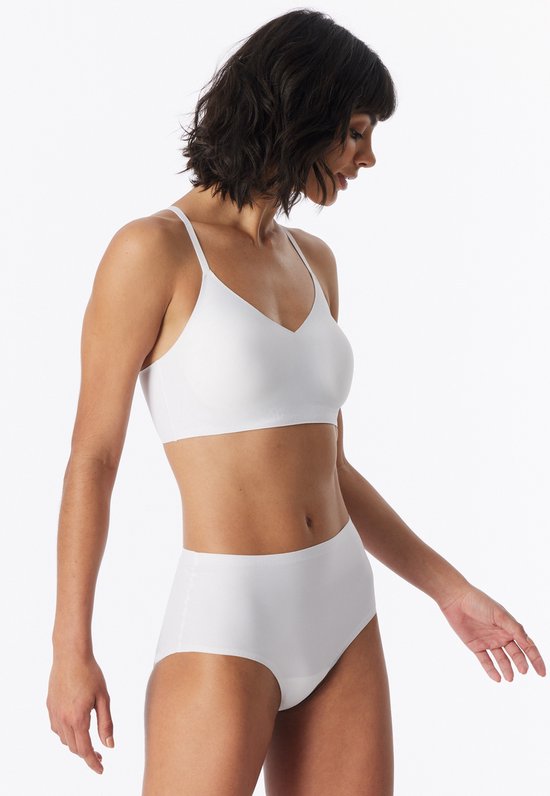 Model in een witte, gladde beha met dunne bandjes en bijpassende slip.