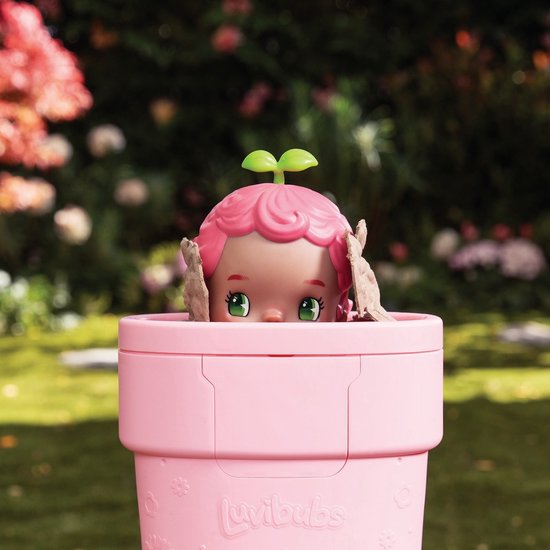 Luvibubs pop kijkt vanuit een roze pot. Het heeft roze, krullend haar met twee groene blaadjes.
