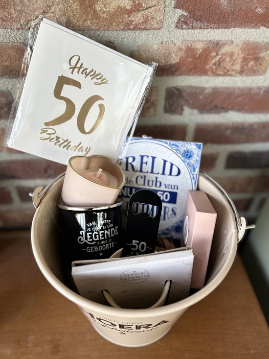 Crème zinken emmer gevuld met cadeautjes voor 50 jaar: kaarten, kaars, mok, opener, tegeltje. Tekst 'Hoera Gefeliciteerd!'.