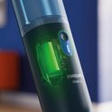 Gros plan du réservoir d'eau transparent de la serpillère électrique Philips OneUp, avec batterie visible.