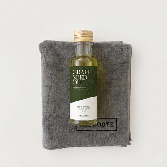 Flesje druivenpitolie van 25 ml op een grijs microvezeldoek met logo.