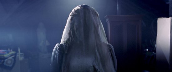 Een vrouw in een bruidsjurk met sluier, met haar rug naar de camera toe.