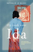 Boek 'Op zoek naar Ida' met op de cover een vrouw met zwarte krullen die met de rug naar de kijker staat, gekleed in een blauwe trui en een rode broek met bloemenpatroon. Ze kijkt naar een schilderij aan de muur.