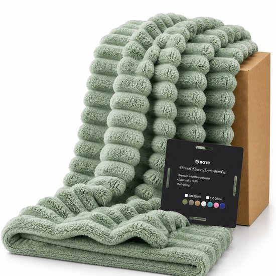 Plaid en polaire vert émeraude avec un motif côtelé, à côté d'une boîte marron.