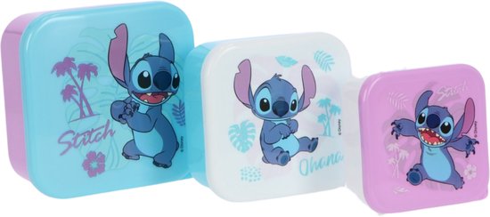 Ensemble de trois boîtes à goûter violettes, blanches et bleu clair avec Stitch. La plus grande est bleu clair avec Stitch et des palmiers, la moyenne est blanche avec Stitch et des plantes, la plus petite est violette avec Stitch.