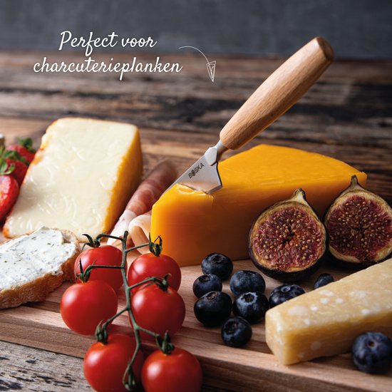 Een BOSKA kaasmes met houten handvat snijdt een stuk kaas op een plank met aardbeien, tomaten, vijgen en blauwe bessen.