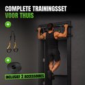 Man doet optrek oefening aan deurpost optrekstang, met TRX-banden en weerstandsband ernaast.
