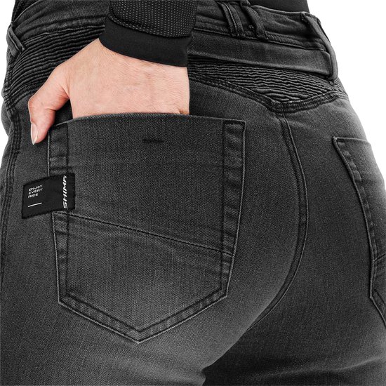 Achterkant van de grijze dames motorjeans met geribbelde heupen en een 'ENJOY EVERY RIDE' label.